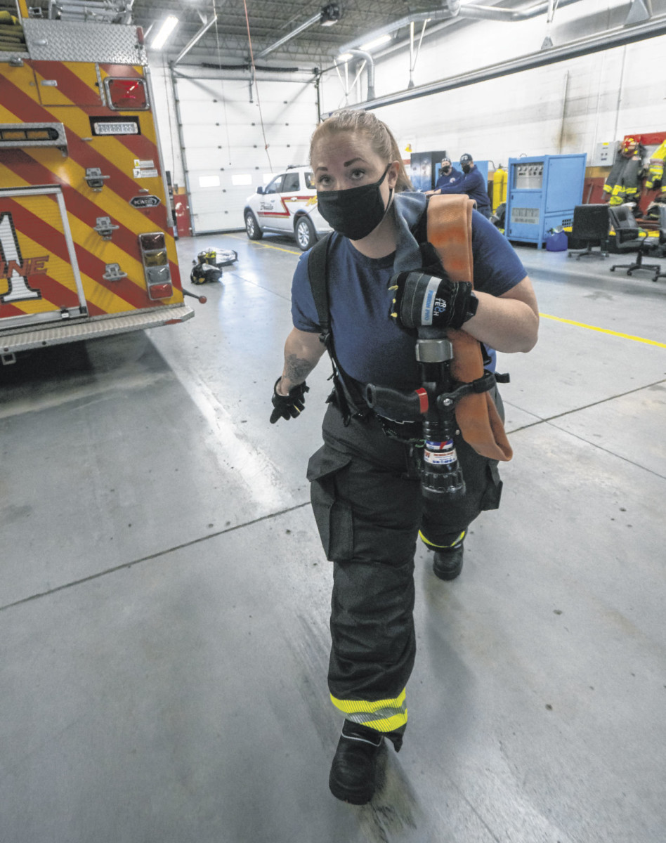 Probationary firefighter/EMT Casey Whitaker pulls a fire hose across the Franklin Fire Station engine 22 bay on Saturday in Franklin. Photos by Scott Roberson | Daily Journal