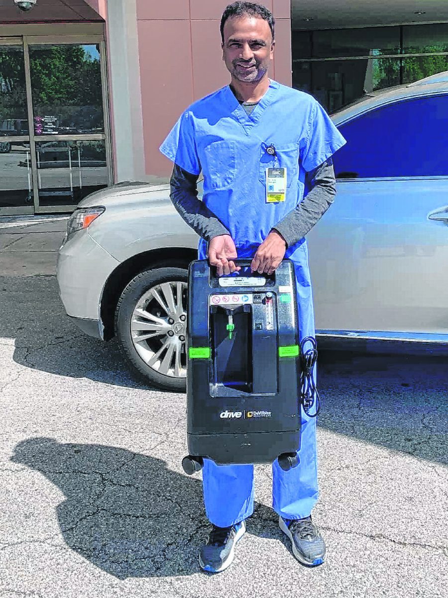 Dr. Ajay Ponugoti, a hospitalist at Franciscan Health Indianapolis, holds one of two oxygen concentrators that the hospital donated to COVID relief efforts in India. Ponugoti, chairman of the India Association of Indianapolis, has helped organize a fundraising drive to assist India as it deals with devastation from the virus. Submitted photo.